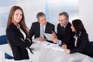 Happy Businesswoman In Front Of Her Colleagues